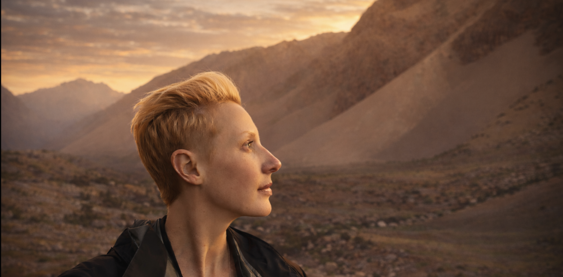 Chris Alyssia in the mountains, looking out across a vast landscape